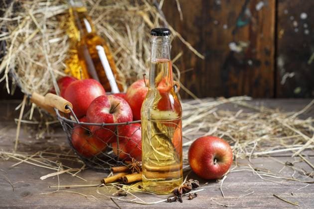 Homemade cider in glass bottles on a barn table. Festive party decor  BEW1EAE86C2