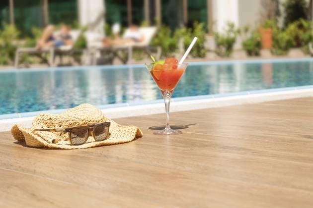 Frischer roter Cocktail mit Eis im Glas, Strandhut und Sonnenbrille am Swimmingpool. Tropischer Saft auf Luxus Urlaub. Konzept Sommerurlaub und Reisen Fresh red cocktail with ice in glass, beach hat and sunglasses on swimming pool. Tropical juice on luxury vacations. Concept summer holiday and travel. Copyright: imageBROKER LARISAxSHPINEVA ibxiqx14289465.jpg