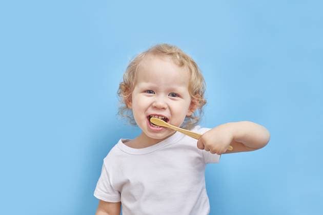Linkshändiges Kind putzt sich die Zähne mit einer Bambuszahnbürste auf einfarbigem Hintergrund mit Platz für Text Left-handed child brushes his teeth with a bamboo toothbrush on a plain background with a place for text Copyright: imageBROKER kutan.ru ibxiqx14276915.jpg ,model released, Symbolfoto ,property released
