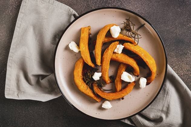 Food, Nahaufnahme von gebackenem Kürbis mit Ricotta und Rosmarin auf einem Teller auf dem Tisch Ansicht von oben Food, Close up of baked pumpkin with ricotta and rosemary on a plate on the table top view Copyright: imageBROKER ElenaxRui ibxiqx14298246.jpg