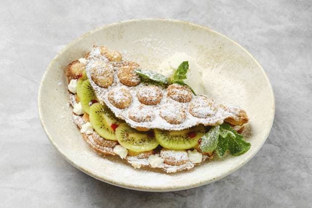 Ein köstliches Dessert mit einer fluffigen Schale, gefüllt mit frischen Kiwischeiben und Schlagsahne, dekoriert mit etwas Puderzucker und einem Hauch von Minze. Perfekt für eine süße Leckerei A delightful dessert showcases a fluffy shell filled with fresh kiwi slices and whipped cream, decorated with a sprinkle of powdered sugar and a touch of mint. Perfect for a sweet treat Copyright: imageBROKER AlekseixIsachenko ibxaii14350830.jpg