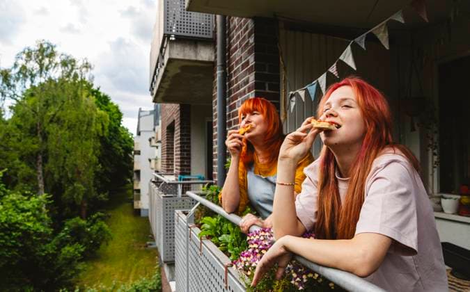 Family enjoying pizza and celebrating together on a balcony model released, Symbolfoto property released, IHF02244