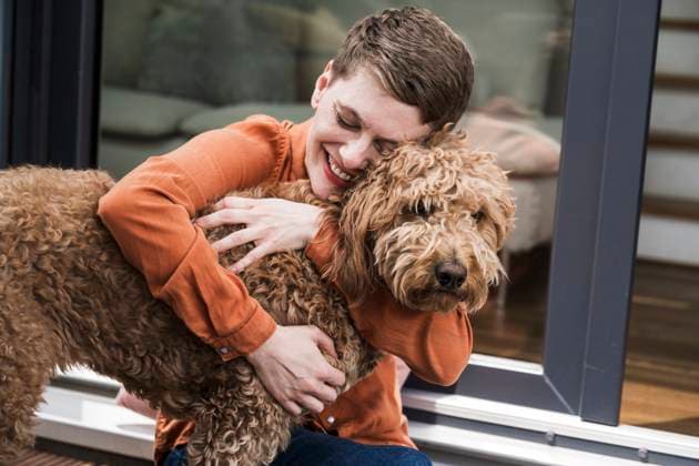 Creative Highlight Symbolbilder Woman hugging her happy dog at home showing affection and joy model released, Symbolfoto property released, UUF34923