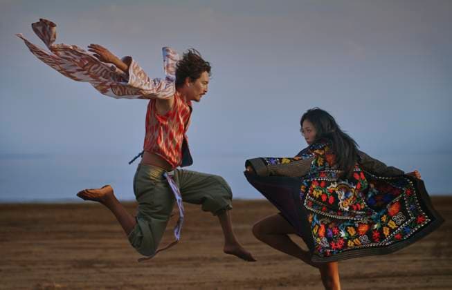 Creative Highlight Symbolbilder Two people dancing and jumping in colorful chapan robes outdoors model released, Symbolfoto property released, AZF00724