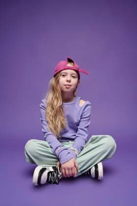 Creative Highlight Symbolbilder Trendy child in streetwear with cap sitting indoors in minimalist setting model released, Symbolfoto, DSHF02476