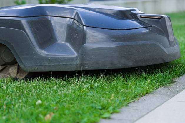 Rasenpflege durch Rasenschnitt mit Mähroboter - Nahaufnahme Rasenroboter *** Lawn care through Lawn cut with Mähroboter Close-up Lawn robot 1077406145