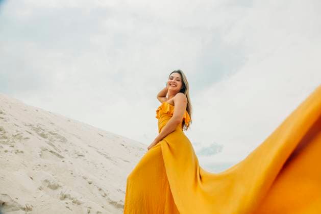 Creative Highlight Symbolbilder Woman in yellow dress walking on sandy beach dune outdoors smiling model released, Symbolfoto, VSNF03675