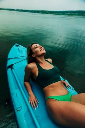 Creative Highlight Symbolbilder Brunette relaxing on sup in bikini during summer vacation by lake model released, Symbolfoto, VSNF03686