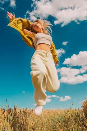 Creative Highlight Symbolbilder Woman in stylish outfit jumping in wheat field on a sunny summer day model released, Symbolfoto, VSNF03713