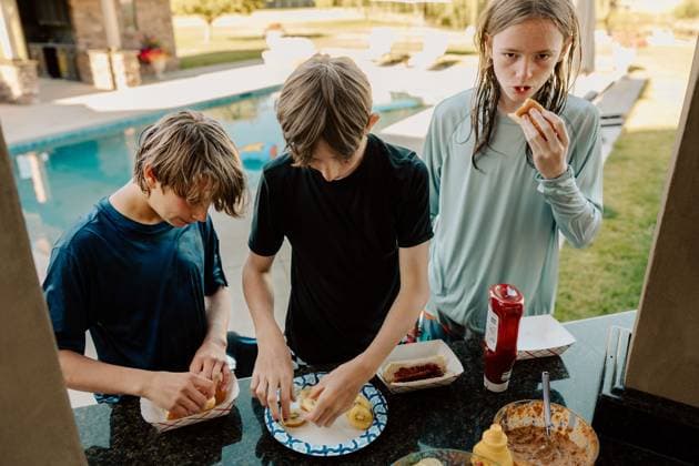 Teenagers preparing hot dogs and fruit by the pool Eagle, Idaho, United States R_PHZD250722-1776536-01 ,model released, Symbolfoto