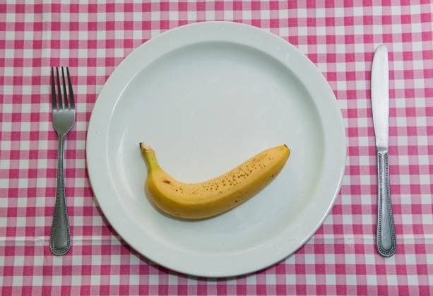 Knife, fork and plate with a banana on it on a red gingham table cloth. banana, beeld, bilt, breakfast, cloth, comida, diet, dietry, dinner, eat, eating, essen, eten, food, fork, fruit, gingham, grub, healthy, image, knife, lunch, maaltijd, mahl, mahlzeit, meal, mealtime, nassen, nobody, nutrition, photo, plate, red,