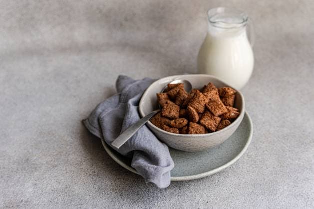 A cozy morning scene featuring a bowl filled with chocolate cereals accompanied by a pitcher of milk. The perfect breakfast setup for a delightful start to the day. Model Released AnnaBogush_ID30021_1013677_006 Copyright: xAnnaxBogushx RECORD DATE NOT STATED