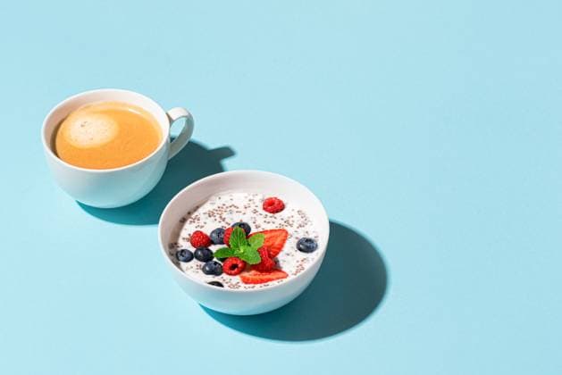 IMAGO Creative, Food, High Protein Frühstück Gesundes Frühstück mit Chia-Schale und Cappuccino-Kaffee auf blauem Hintergrund, trendiges Design mit hartem Licht. Chia-Pudding mit Beeren. Gesunde pflanzenbasierte Ernährung, Fitness Sommer Rezept. Healthy breakfast with chia bowl and cappuccino coffee on blue background, trendy design with hard light. Chia pudding with berries. Healthy plant based diet, fitness summer recipe. (License=RF) Copyright: xZoonar.com OksanaxBratanovax 23783325