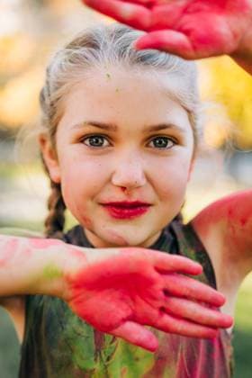 Creative Highlights Symbolbilder Young girl playing with holi colors making a frame with her hands North Andover, Massachusetts, United States CR_FKNH250723-1791786-01 ,model released, Symbolfoto