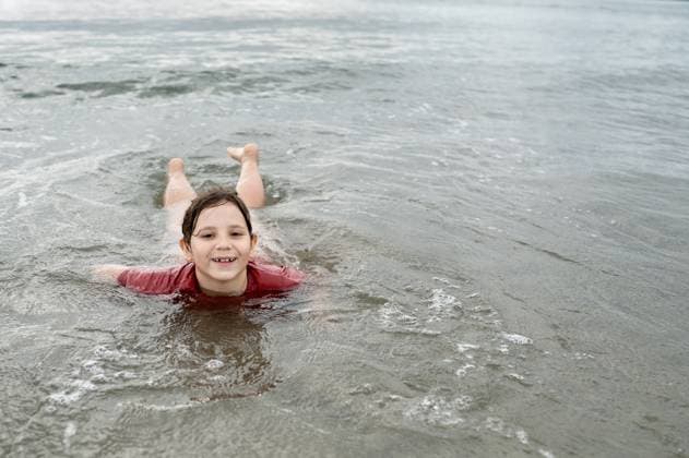 Creative Highlight Symbolbilder Smiling child girl swimming in sea water. Aberdyfi, Wales, United Kingdom R_JNDO250723-1793615-01 ,model released, Symbolfoto