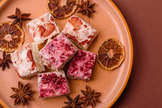 Nougat oder weißes Karamell mit Haselnüssen und Erdbeerstücken. Weißer Nougat Nougat oder weißes Karamell mit Haselnüssen und Erdbeerstücken. Weißer Nougat (License=RF) Copyright: xZoonar.com TetianaxChernykovax 23798392