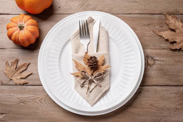 Herbstlich gedeckter Tisch mit Kürbissen und Ahornblättern. Thanksgiving Day or Halloween place setting with pumpkins and dry maple leaves on wooden background, top view. Neutral autumn holiday table setting. (License=RF) Copyright: xZoonar.com OksanaxBratanovax 23796776