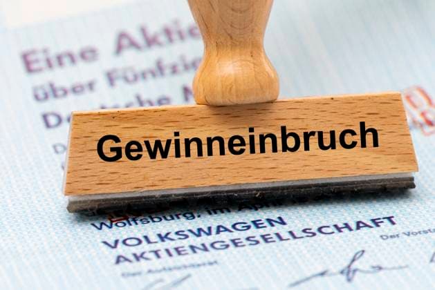 Gewinneinbruch bei VW Volkswagen Ein Holzstempel ist beschriftet mit Gewinneinbruch und liegt auf einer Aktie der Volkswagen AG - Symbolbild *** Profit slump at VW Volkswagen A wooden stamp is labeled with profit slump and lies on a Volkswagen AG share Symbolic image