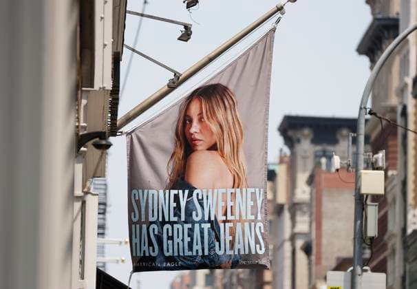 Ad posters of Sydney Sweeney in denim for fashion retailer American Eagle Outfitters hang above pedestrians in the SOHO section of Manhattan on Thursday, July 31, 2025 in New York City. American Eagle s good jeans ads with Sydney Sweeney have sparked a debate on race and beauty standards.  NYP20250731132 JOHNxANGELILLO