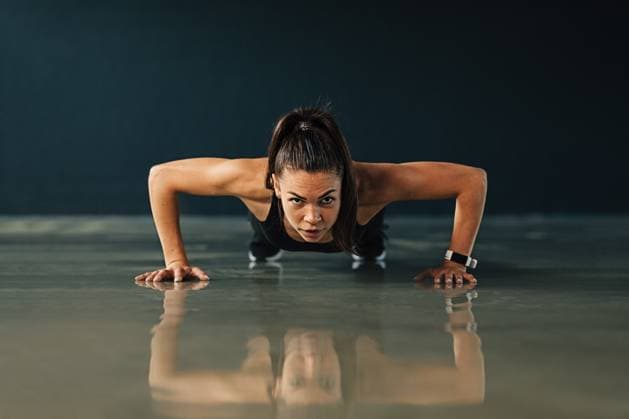 Creative Highlights Symbolbilder Frau in Sportkleidung beim Training in einem Haus. Starke junge Frau macht Liegestütze und schaut in die Kamera. Woman in sportswear exercising indoors. Strong young woman doing push ups and looking at camera. (License=RF) ,model released, Symbolfoto Copyright: xZoonar.com ArtemxVarnitsinx 23812579 ,model released, Symbolfoto ,property released
