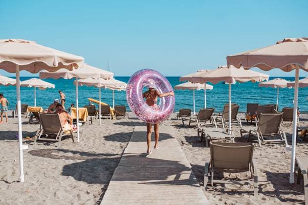 Rear view of girl walking to the beach with swim ring. summer beach holiday. Rear view of girl walking to the beach with swim ring in hand. Summer beach holiday. model released