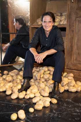 abb Oliver Mommsen Schauspieler Hauptdarsteller sitzt Berg Kartoffeln anlaesslich der Deutschen Erstauffuehrung vom Theaterstueck Vanja von der Komoedie am Kurfuerstendamm im Neuen Haus des Berliner Ensemble am 03.August 2025 in Berlin Berlin Deutschland