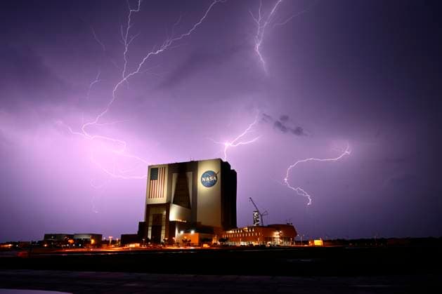News Themen der Woche KW32 Lightning flashes across the sky over the Kennedy Space Center s Vehicle Assembly Building as SpaceX waits out the poor weather to launch its Falcon 9 rocket with 28 Starlink satellites on mission 10-30 from Launch Complex 40 at the Cape Canaveral Space Force Station, Florida on Monday August 4,2025. SpaceX waited until 3:57 AM to successfully launch its rocket from the Space Coast.  CCP20250804004 JOExMARINO