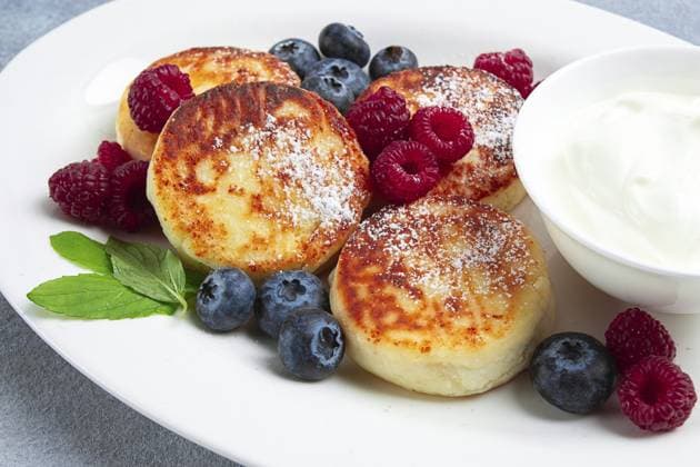IMAGO Creative, Food, High Protein Frühstück Frühstück, Hüttenkäsekuchen, mit frischen Beeren und saurer Sahne, Draufsicht, Nahaufnahme, ohne Personen Breakfast, cottage cheese cakes, with fresh berries, and sour cream, top view, close-up, no people Copyright: imageBROKER Didebashvili ibxgai14533287.jpg