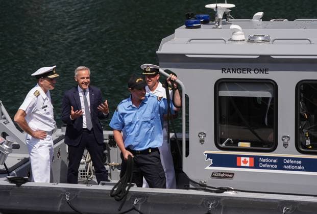 August 4, 2025, Nanoose Bay, Bc, CANADA: Prime Minister Mark Carney talks with Royal Canadian Navy Commander, Vice-Admiral Angus Topshee, left, and Commanding Officer of the CFMETR Craig Piccolo, back right, as they arrive on a boat to tour the Canadian Forces Maritime Experimental and Test Ranges (CFMETR), in Nanoose Bay, B.C.,, on Monday, August 4, 2025. Nanoose Bay CANADA - ZUMAc35_ 20250804_zaf_c35_079 Copyright: xDarrylxDyckx