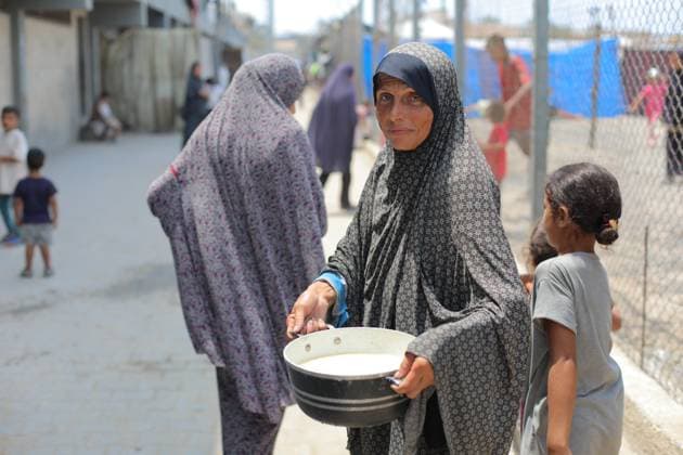 Food distributed to Palestinians fighting hunger in Gaza BUREIJ REFUGEE CAMP, GAZA - AUGUST 11: Palestinians wait with pots in their hands as a charitable organization distributes food to Palestinians suffering food crisis under Israeli blockade in Bureij refugee camp, Gaza on August 11, 2025. As Gaza teeters on the brink of famine under the ongoing Israeli blockade, Palestinians continue to face difficulties accessing basic supplies. Hassan Jedi Anadolu Gaza Gaza. Editorial use only. Please get in touch for any other usage.  Copyright: x2025xAnadoluxHassanxJedix