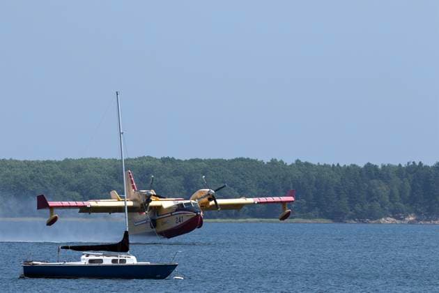 August 11, 2025, Shediac Bridge, Nb, Canada: A Quebec Water Bomber scoops water from Shediac Bay as the two Quebec based bombers help fight the forest fire in the Irishtown, N.B. area on Monday August 11, 2025. Shediac Bridge Canada  - ZUMAc35_ 20250811_zaf_c35_061 Copyright: xRonxWardx