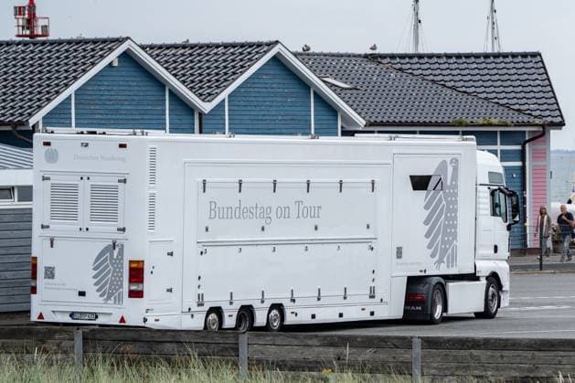 Infomobil des Deutschen Bundestags mit einer mobilen Wanderausstellung zum deutschen Parlamentarismus wird am Hafen von List auf Sylt in die Fähre Romoexpress nach Dänemark verladen;Parlamentarische Sommerferien am Meer - Bundestag on Tour - Bundestag unterwegs, Sylt Schleswig-Holstein Deutschland List *** Infomobile of the German Bundestag with a mobile traveling exhibition on German parliamentarianism is loaded onto the Romoexpress ferry to Denmark at the port of List on Sylt Parliamentary summer vacations by the sea Bundestag on Tour Bundestag on the road, Sylt Schleswig Holstein Germany List