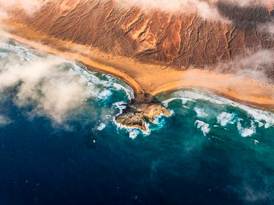 Creative Highlights World Aerial view of breaking waves at Cofete beach, Fuerteventura Cofete, Canary Islands, Spain CR_ROMO250811-1804130-01