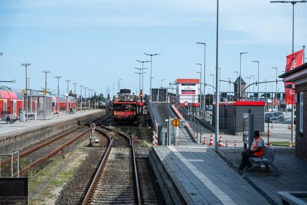 Verladung roter Sylt-Shuttle der DB am Bahnhof Westerland auf der Nordseeinsel Sylt - Verladestelle;Blick auf einen Teilabschnitt der von Hamburg und nach Sylt führenden Marschbahn mit dem Hindenburgdamm in Schleswig-Holstein zwischen den Stationen Niebüll und Westerland auf der Insel Sylt, Berlin Berlin Deutschland ORTSANGABE *** Loading of DBs red Sylt Shuttle at Westerland station on the North Sea island of Sylt Loading point View of a section of the marsh railroad leading from Hamburg and to Sylt with the Hindenburgdamm in Schleswig Holstein between Niebüll and Westerland stations on the island of Sylt, Berlin Berlin Germany LOCATION