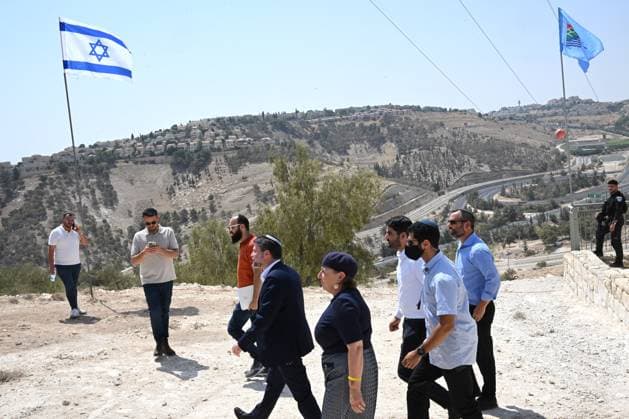 Israeli far-right Finance Minister Bezalel Smotrich (C) arrives to speak at a press conference near Ma ale Adumim settlement, to announce his plan to approve more than 3,000 Jewish housing units, schools, health facilities and a country club in the controversarial E1 settlement project in the West Bank, on Thursday, August 14, 2025.  JER2025081410 DEBBIExHILL