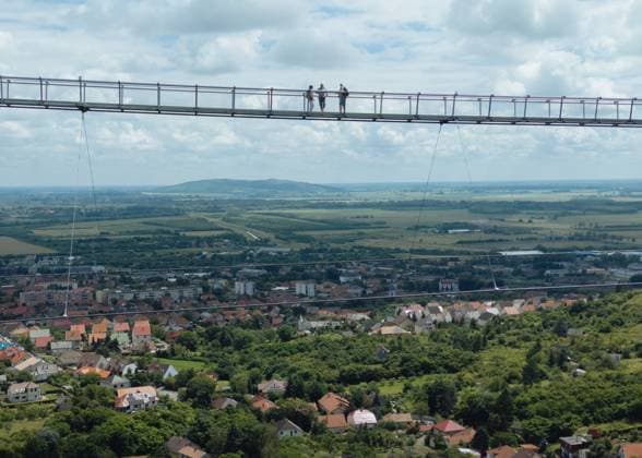 Longest two-way suspension bridge opens to the public for the first time in Hungary SATORALJAUJHELY, HUNGARY - JUNE 5: An aerial view of the world s longest two-way suspension bridge, which was opened to the public on 5th June 2024, in Satoraljaujhely, Hungary. The nearly 800-meter-long structure connects the two points of the city, Var-Hill and Szar-Hill, at a height of 80 meters. The bridge, which will have a glass floor in the central part, is being built as part of the Tokaj-Zemplen Development Programme, with a budget of £9.3 million (HUF 4 billion). The walkway will have a width of 1.2m and descend by 27m at its lowest point, resulting in a 15% steepness at its most extreme. The design of bridge prioritizes minimal physical impact on  Copyright: x2025xAnadoluxRobertxNemetix