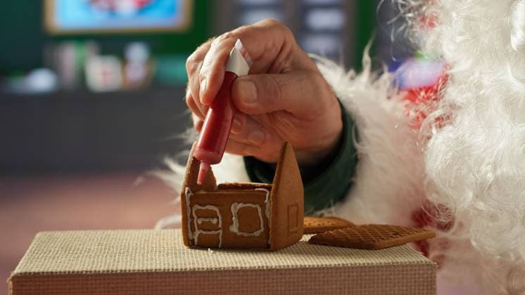 IMAGO Creative, Weihnachten, Food, Backen, Lebkuchen Father Christmas decorates homemade gingerbread house with frosting Father Christmas decorates homemade gingerbread house with frosting and beads, North Pole log cabin workshop. Santa keeping the festive tradition of baking sweet treats with cinnamon. Camera A., model released, , property released, , 63271680.jpg RECORD DATE NOT STATED