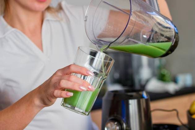 A girl in a white T-shirt pours a green smoothie into a glass. A girl in a white T-shirt pours a green smoothie into a glass. High quality photo, model released, , 63577006.jpg RECORD DATE NOT STATED