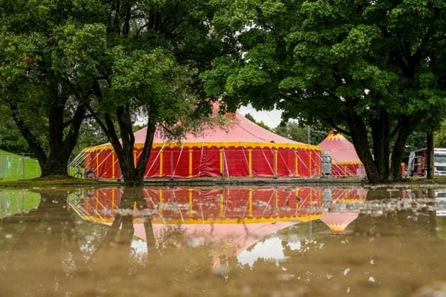 IMAGO Creative, Jahreszeit Sommer, Regen, Sommerregen Rotes Zirkuszelt, das sich im Wasser spiegelt Großes, rotes Zirkuszelt inmitten einer Überschwemmung aufgrund von starkem Regen. Das Wasser spiegelt das Zelt und die umliegenden Bäume wider (License=RF) Copyright: xZoonar.com SandraAlkadox 23840878