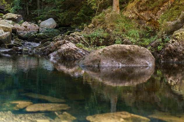 Aus dem Nature Art Mensch & Natur - Farbige Symbiosen Kalender 2026: River Rock Bodypainting und Photoshooting mit Model Darky im Okertal im Harz bei Goslar. Bodyart-Künstler: Jörg Düsterwald
