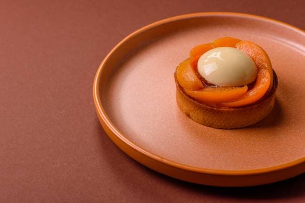 Kuchen, süße runde Torte mit Aprikosenstücken, Sahne und Nüssen. Süße Torte mit Pfirsich Pie, sweet round tart with apricot pieces, cream and nuts. Sweet tart with peach as a food background (License=RF) Copyright: xZoonar.com TetianaxChernykovax 23882217