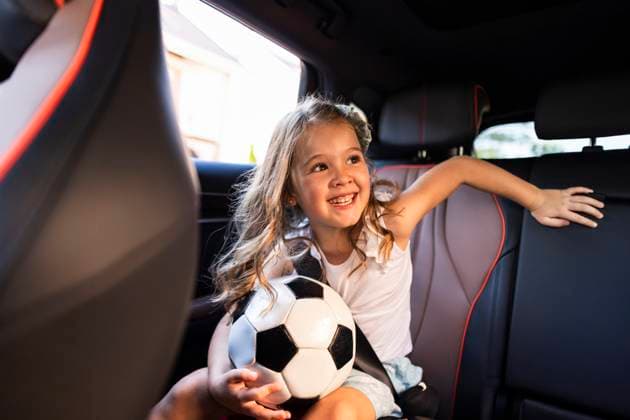 Creative Highlight Symbolbilder Smiling daughter with soccer ball in car on morning school routine model released, Symbolfoto, JCCMF14076