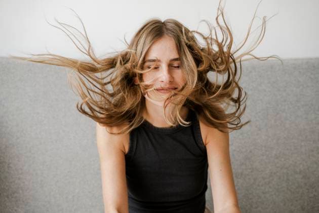 Creative Highlight Symbolbilder Smiling woman indoors with wild hair blowing in the wind model released, Symbolfoto property released, KNSF11648