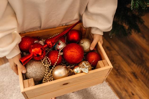 Child holding wooden box filled with Christmas ornaments indoors model released, Symbolfoto property released, ELMF01200