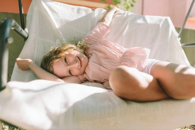 Creative Highlight Symbolbilder Child relaxing on garden swing with golden curls in soft sunlight model released, Symbolfoto property released, SIF01398