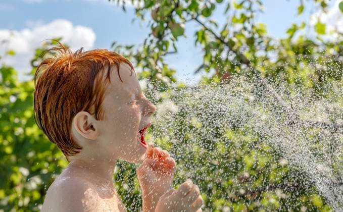 Red-haired child playing and splashing in outdoor pool on a sunny day model released, Symbolfoto, MBLF01008
