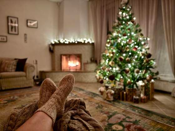 Cozy mood on Christmas Eve with fire in fireplace, Christmas tree. Women s feet in cozy wool socks warming up by fireplace. Cozy mood on Christmas Eve with fire in fireplace, Christmas tree. Women s feet in cozy wool socks warming up by fireplace, 64380998.jpg RECORD DATE NOT STATED