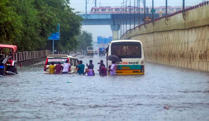 NEW DELHI, INDIA - AUGUST 29: Passengers step out after a bus got stuck on a waterlogged road during heavy rainfall at Vinod Nagar area near NH-24 on August 29, 2025 in New Delhi, India. The India Meteorological Department (IMD) issued orange alert for many parts of Delhi-NCR. Due to rain and waterlogging in some pockets, traffic movement was slow. (Photo by Raj K Raj Hindustan Times) Delhi Reel Under Waterlogging, Traffic Snarls After Heavy Rains