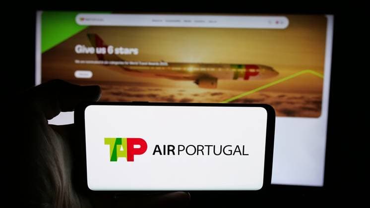 Illustration in Germany. In this photo illustration, a person is holding a cellphone with the logo of Portuguese airline company TAP Air Portugal on screen in front of webpage. Germany Copyright: xTimonxSchneiderx xSOPAxImagesx TSCHNEIDER_55056 TAP Air Portugal P5861596