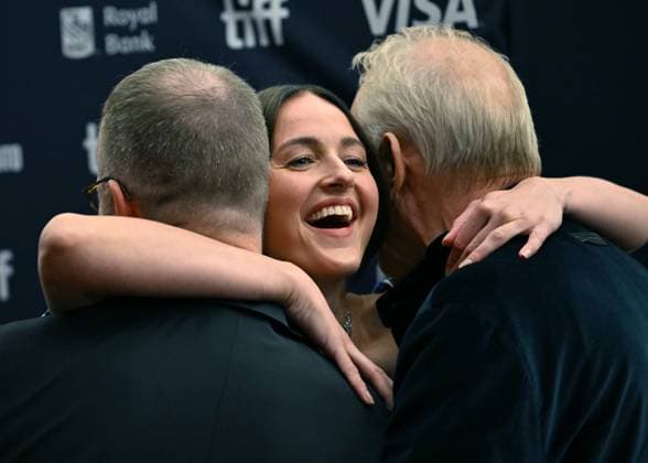 Renate Reinsve hugs Stellan Skarsgard (R) and director Joachim Trier attend the premiere of Sentimental Value on opening night of the Toronto International Film Festival at the Princess of Wales Theatre in Toronto, Canada on Thursday, September 4, 2025. The festival is celebrating its milestone 50th edition this year and will feature 291 films from around the world.  TOR2025090438 CHRISxCHEW